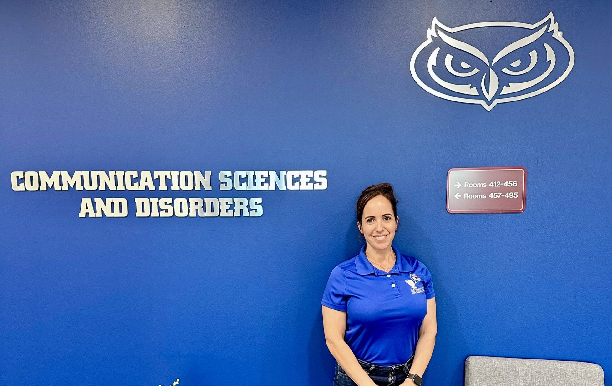 Maria Toth Standing in front of an FAU banner.